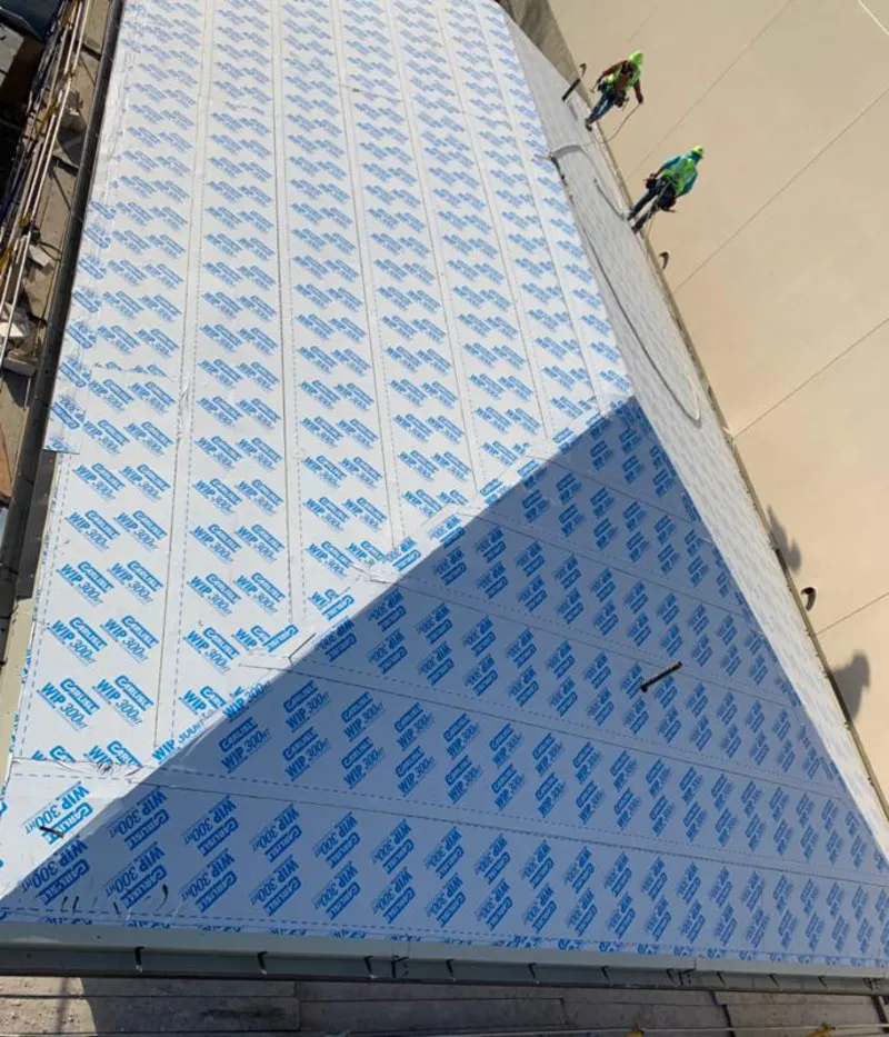 Professional roofers installing underlayment on a metal roof in Peterborough